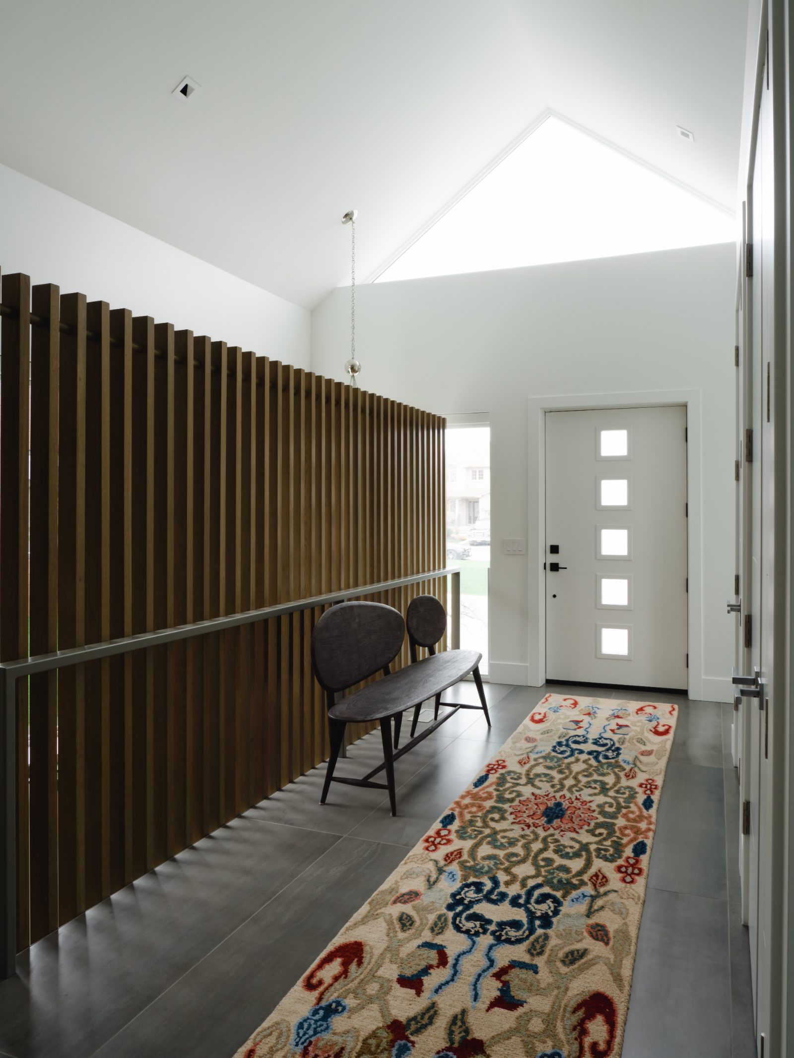 Front entry with white-oak slat screen and large-format tile floor