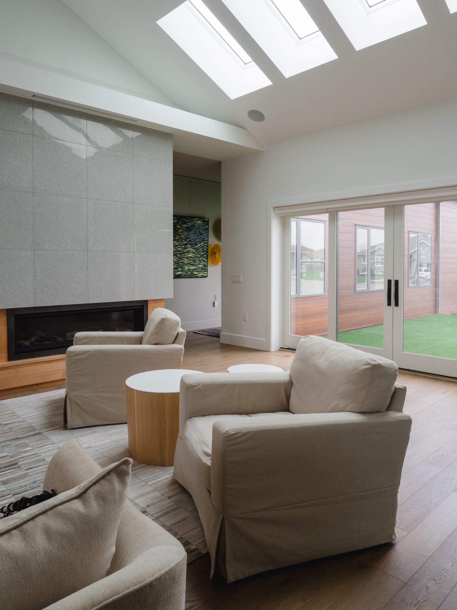 Living room with polished tile fireplace wall under a row of new skylights
