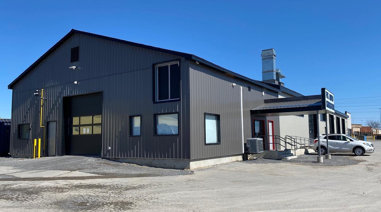 Finished shop exterior in dark steel cladding with covered entry