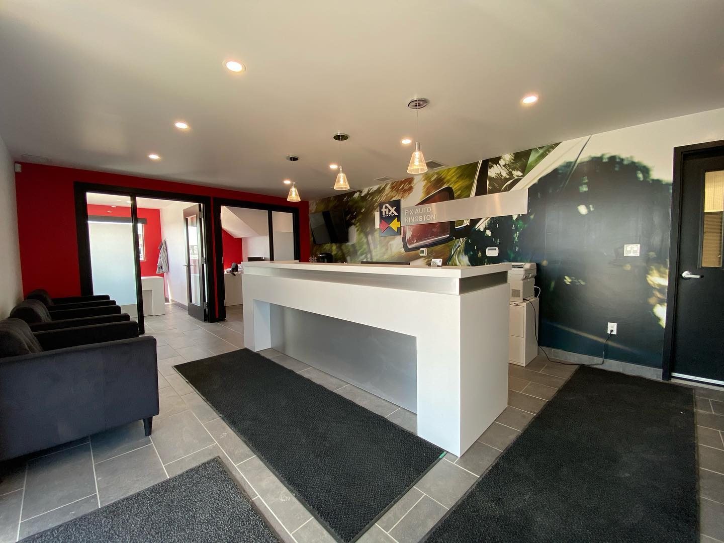 New reception with white service desk and full-wall graphic