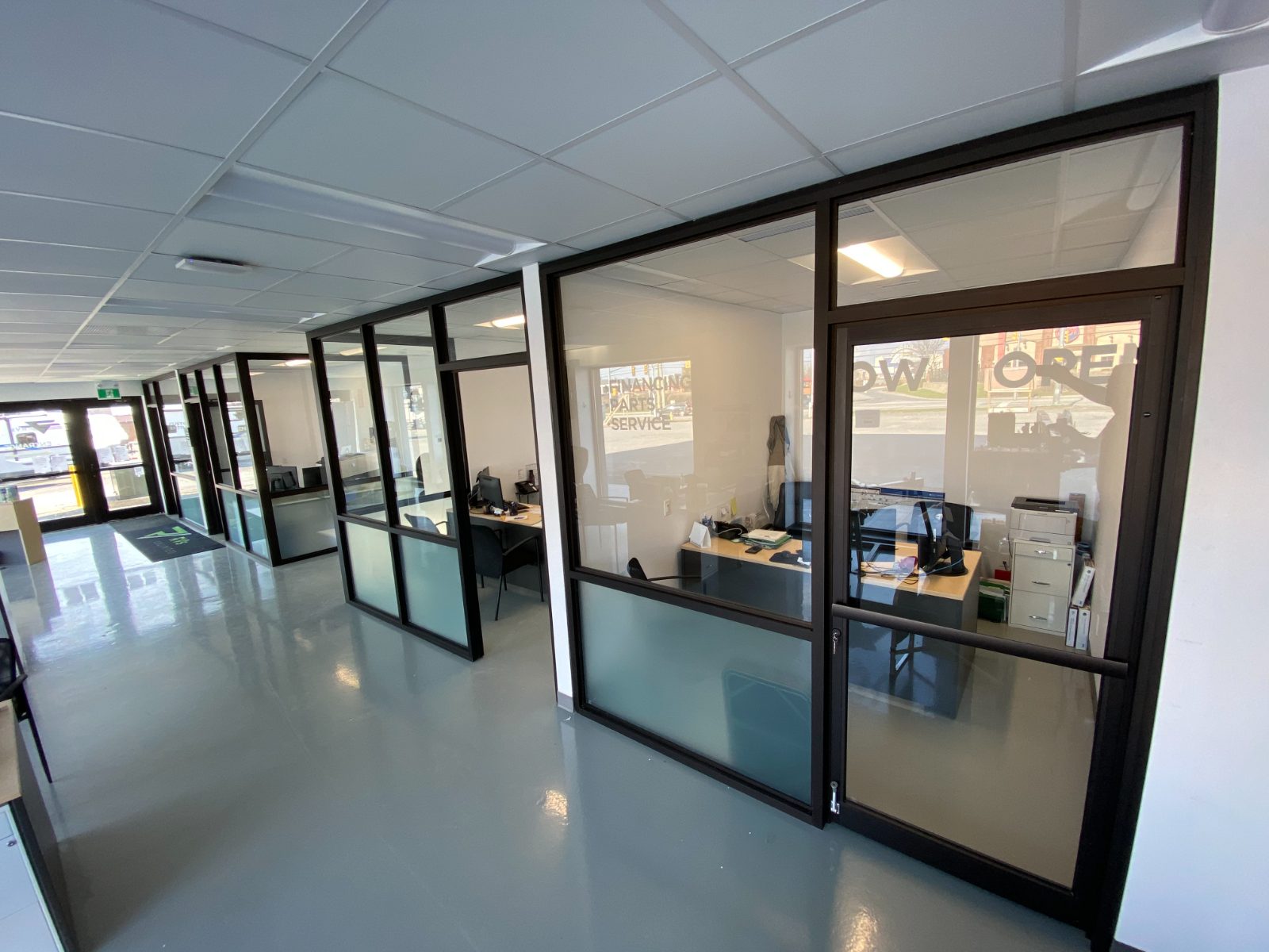 New glass-front offices along a finished dealership corridor