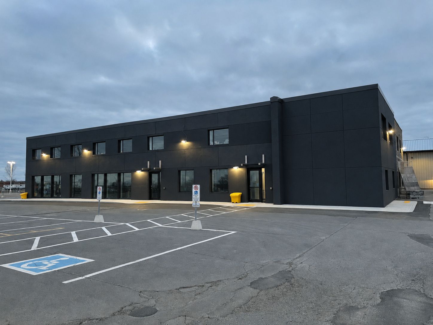 Two-storey matte-black office building at dusk