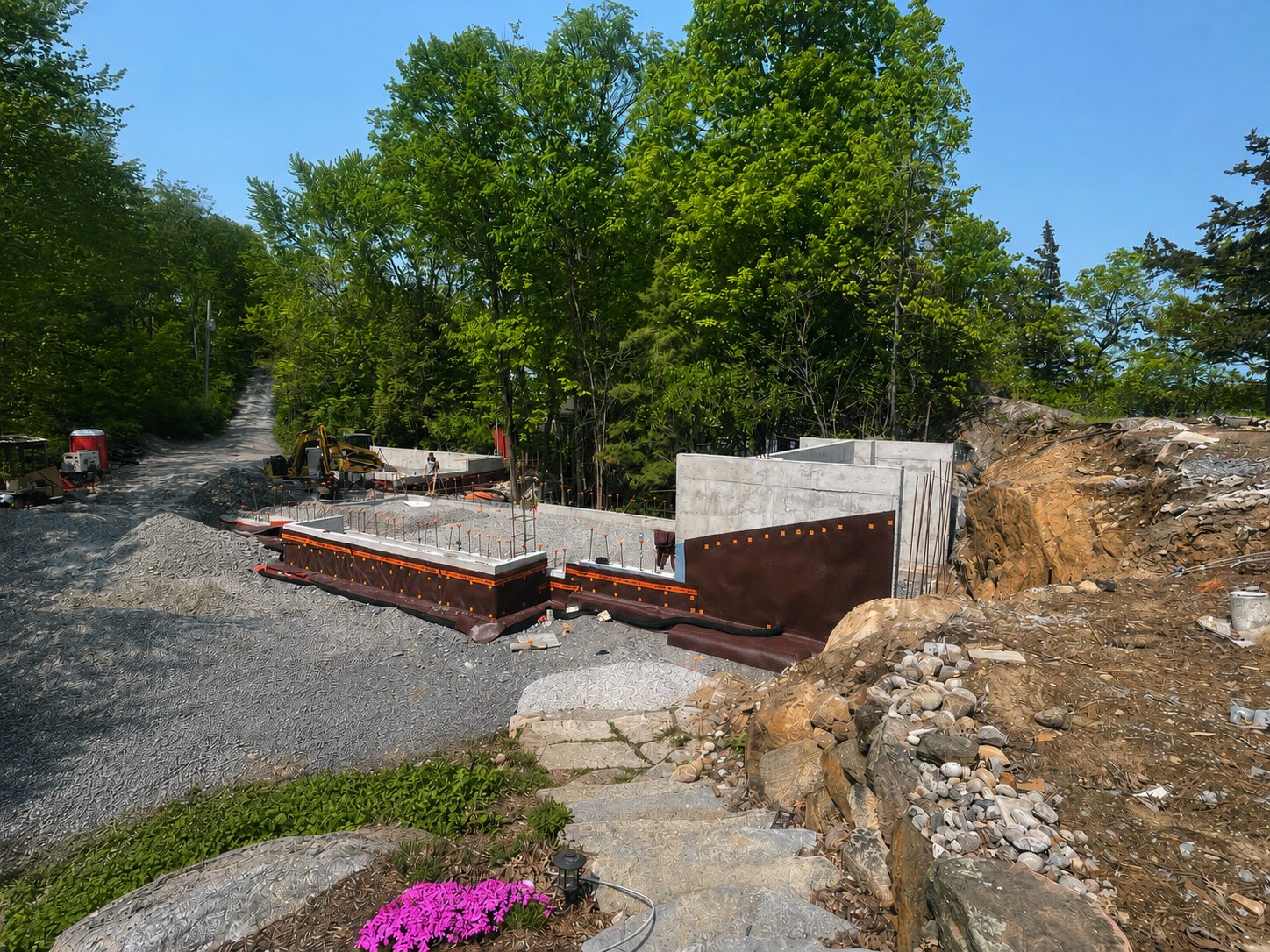 Foundation with waterproofing membrane and drainage board on engineered gravel