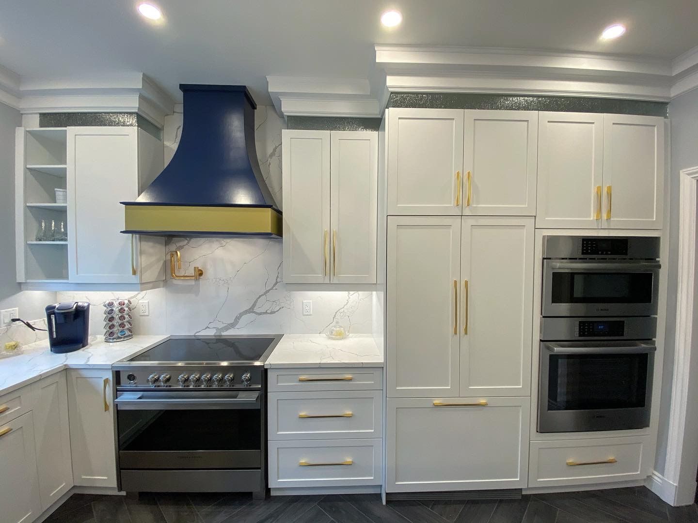 Kitchen range wall with navy hood and gold hardware