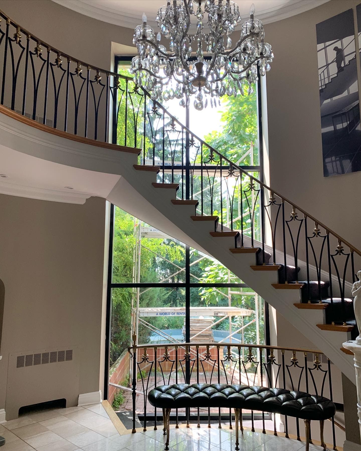 Restored curved staircase under a crystal chandelier