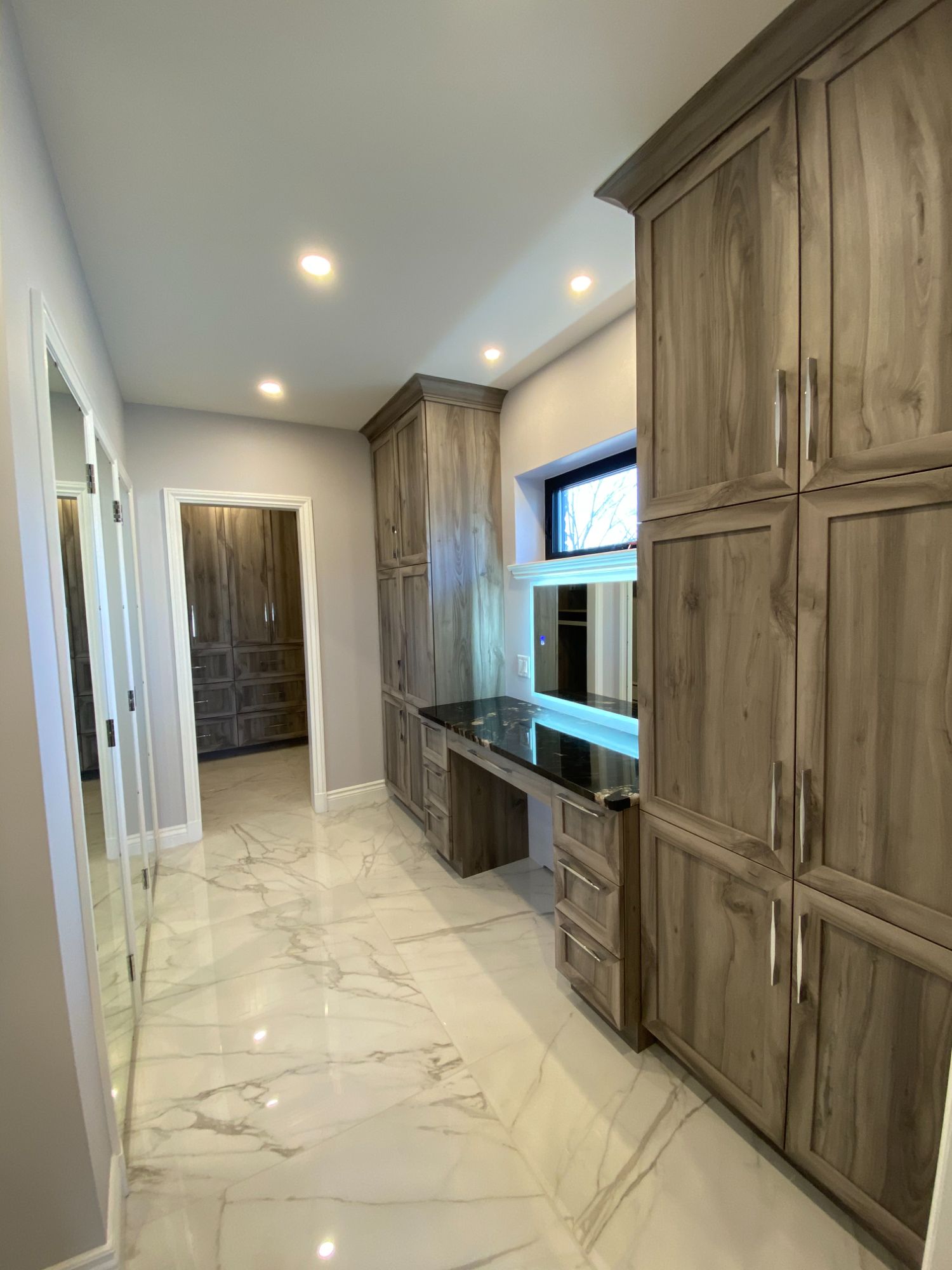 Custom walnut dressing room with marble floors