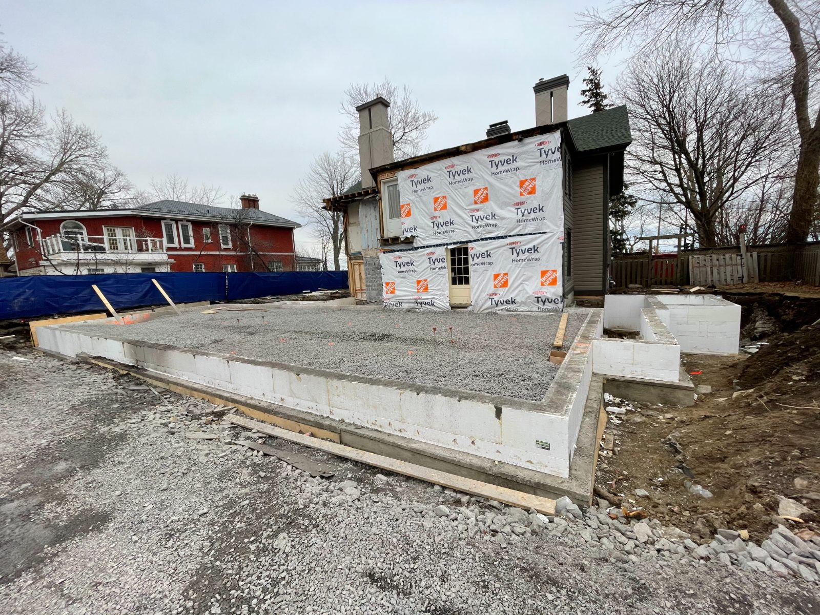 ICF foundation and gravel drainage plane for the addition, behind the wrapped heritage house
