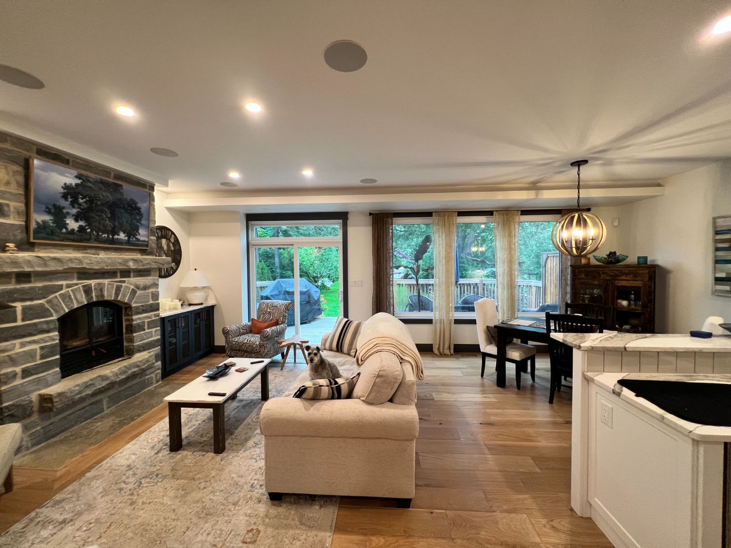 Great room with a dry-stacked stone fireplace open to the yard