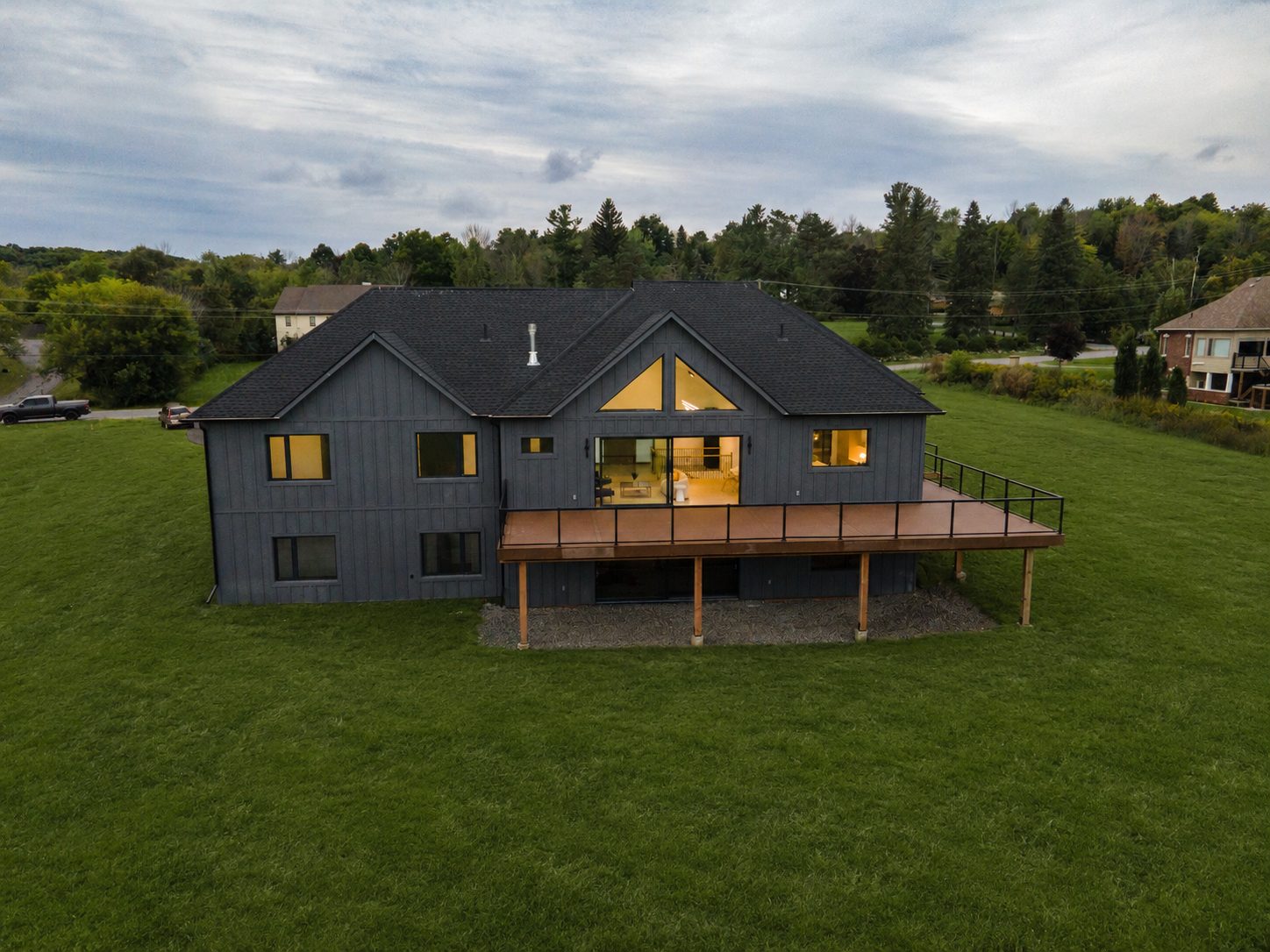 Rear elevation at dusk with the great room lit