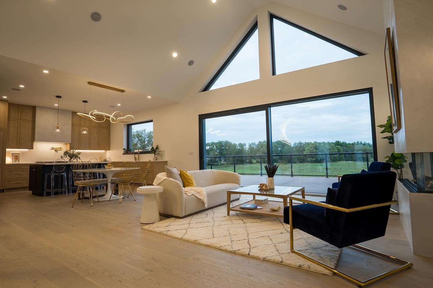 Vaulted great room with gable glazing and sliders opening to the deck