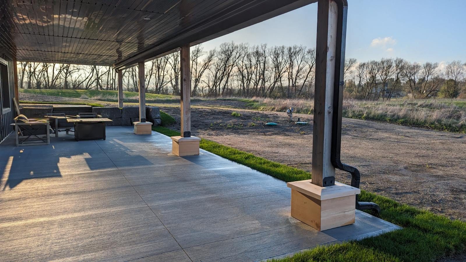 Covered patio under the deck at sunset, looking over the prairie