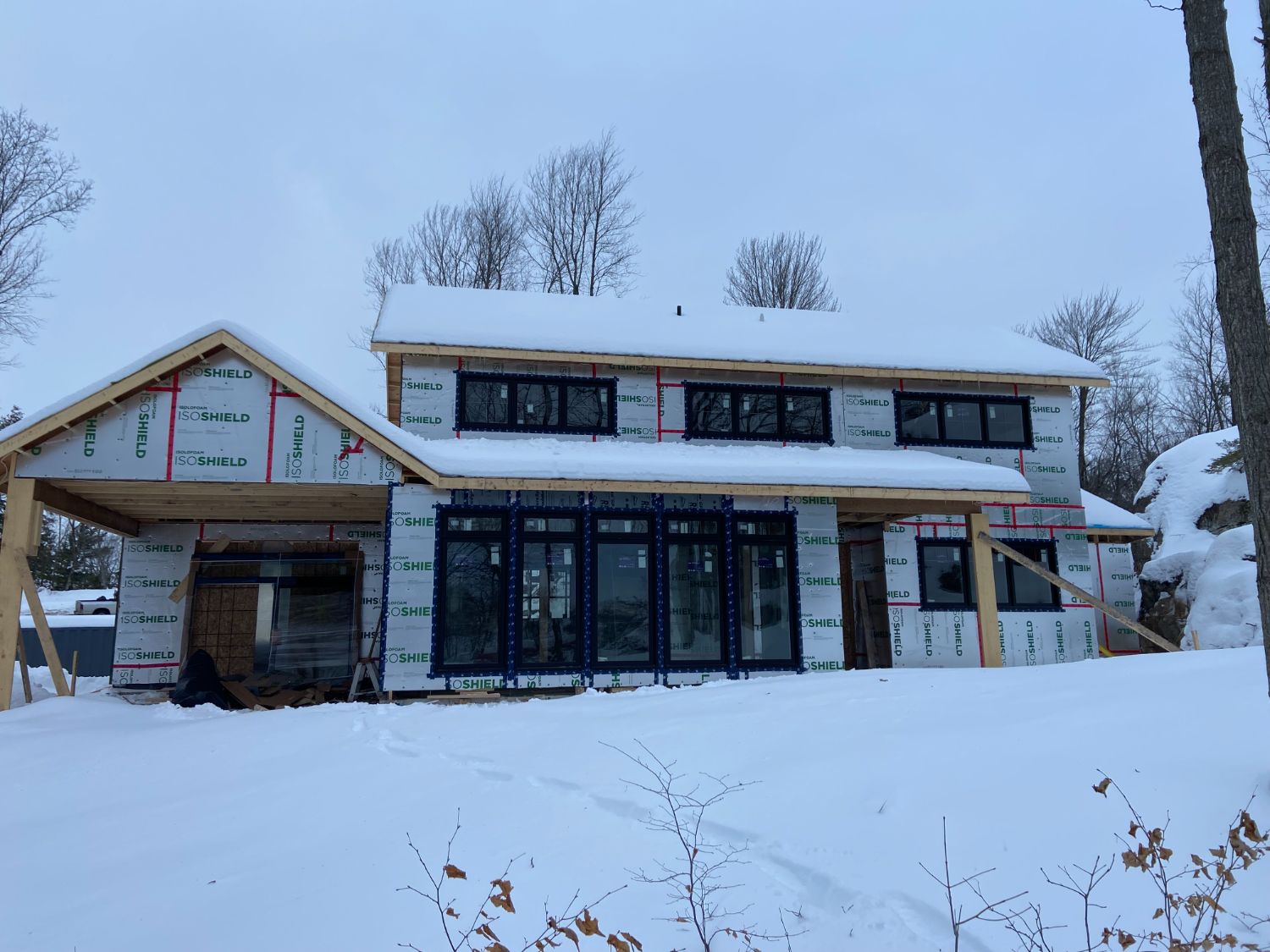 Framed and wrapped house under winter snow