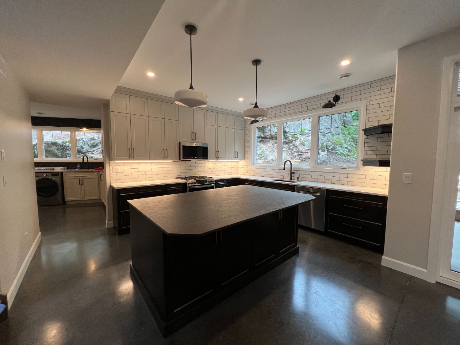 Finished kitchen with black island and white subway tile
