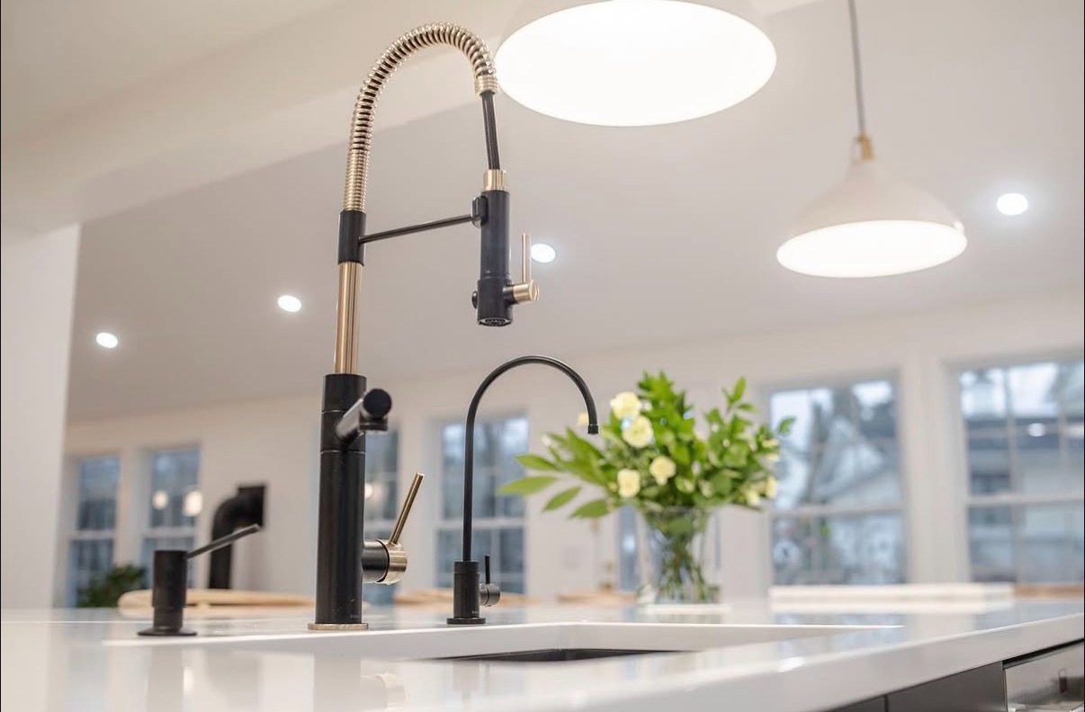 Black and brass pro-style faucet at the island sink