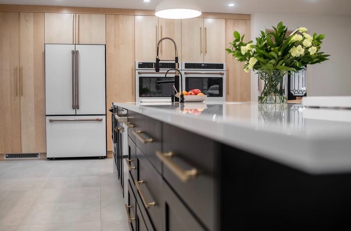 Kitchen with white Café appliances, maple cabinetry and black island