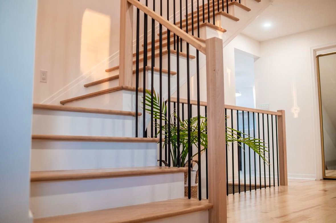 White staircase with black metal spindles and wood accents